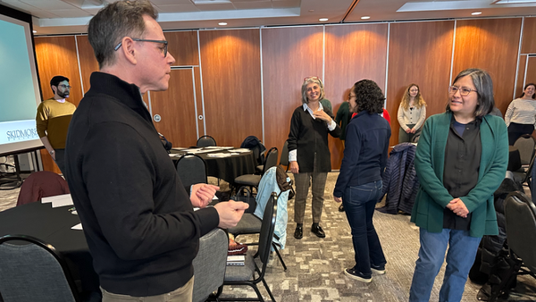 Dennis Schebetta, assistant professor of theater, speaks with colleagues.